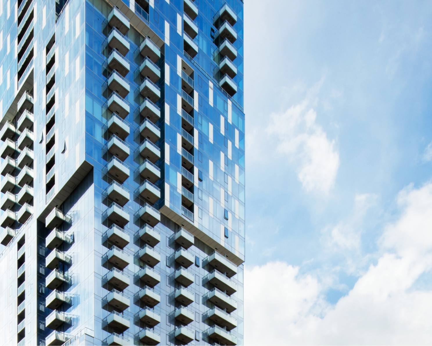 The blue façade of a new condo tower located in the Ville-Marie borough